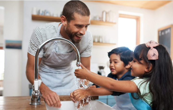 A father and children enjoy clean, filtered, softened water from the faucet. 